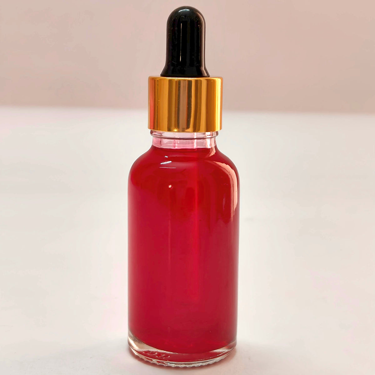 Red liquid dropper bottle on a white background