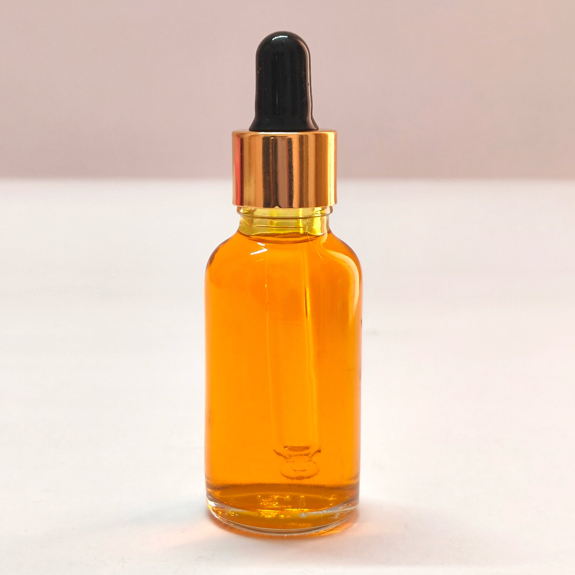 Amber glass dropper bottle with black cap on a white background