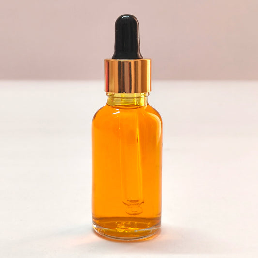 Amber glass dropper bottle with black cap on a white background
