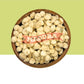 A top-down view of dried Medura (MoringaSeedKernel) seeds in a round wooden bowl, set against a split green and white background with a red 'MEDURA' brand watermark overlay.