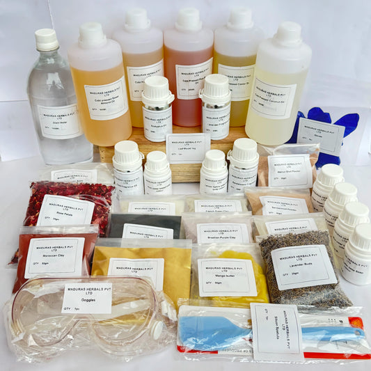 A large collection of herbal products from Madras Herbs Pvt Ltd, including multiple plastic bottles of liquid extracts, small vials, loose herbal powder bags, dried herbs, and a glass decanter, all neatly arranged on a white surface.