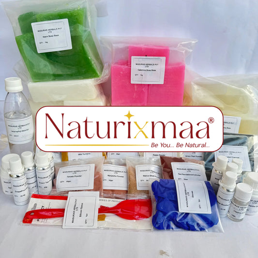A collection of handmade soap bars and wax melts from Naturixmaa arranged on a white surface with their labels visible. The soaps include green, pink, cream, and blue varieties, alongside wax melts in small packets, bottles of liquid, and red and white mixing tools, all under a central brand logo overlay.