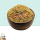 A wooden bowl with Vetiver Scrub Powder with White and Blue Background