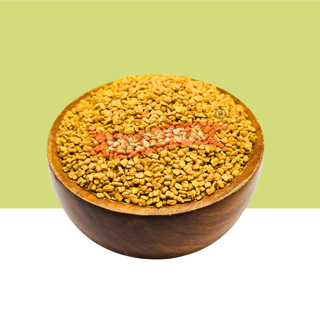 A wooden bowl filled with golden-yellow fenugreek seeds, centered against a split light green and white background.